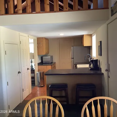 a kitchen with a table chairs refrigerator and cabinets
