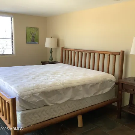a bed sitting in a bedroom next to a window
