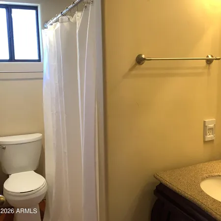 a bathroom with a granite countertop sink toilet and a mirror