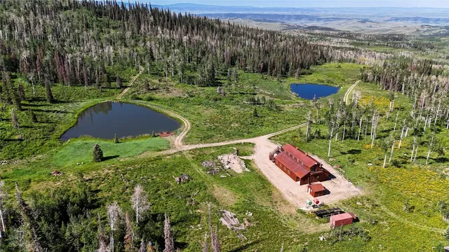 an aerial view of a house with a yard and lake view