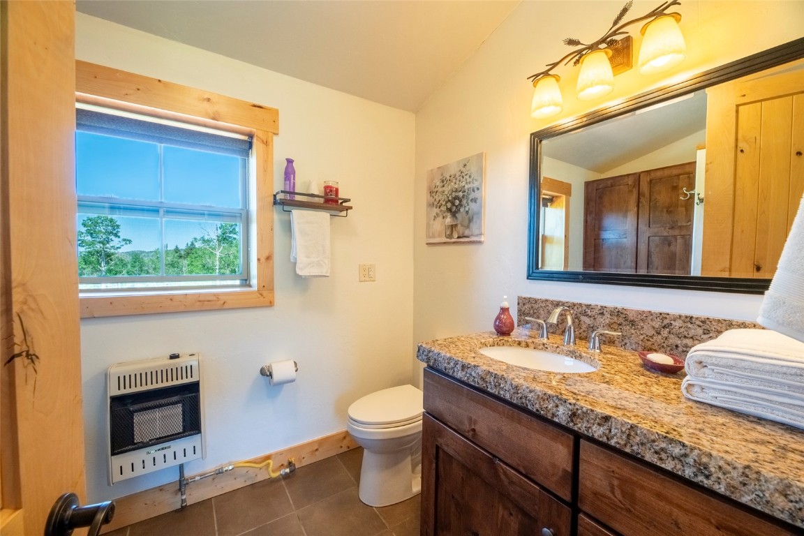 51735 County Road 80 Hayden, CO 81639 - Photo 37 of 46 a bathroom with a granite countertop toilet sink and mirror
