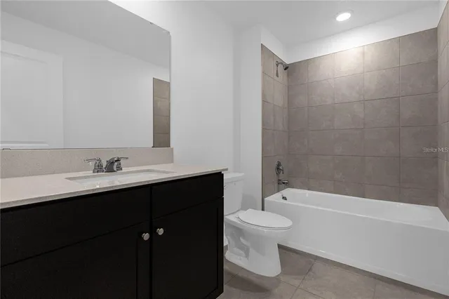 a bathroom with a bathtub shower sink mirror vanity and toilet
