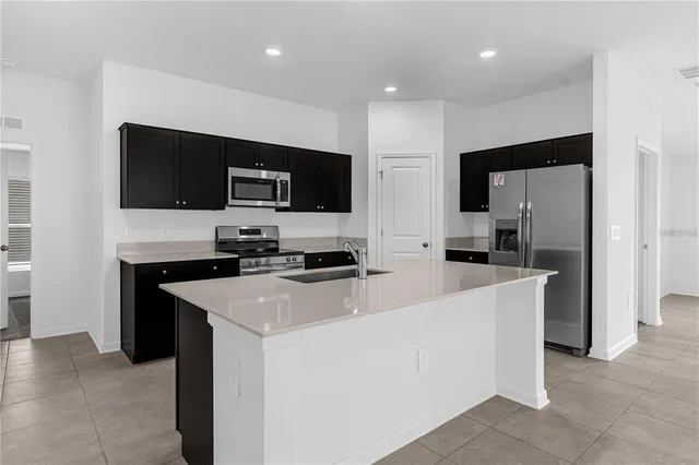 a kitchen with stainless steel appliances a stove refrigerator and microwave