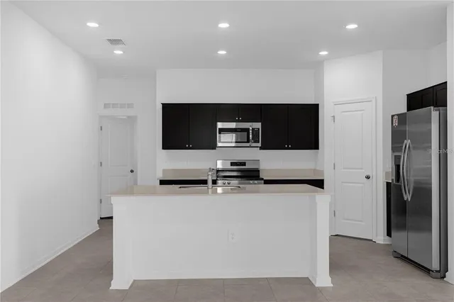 a kitchen with stainless steel appliances a refrigerator and a microwave