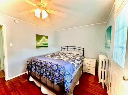 a bedroom with a bed a chandelier and dresser