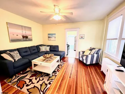 a living room with furniture and wooden floor