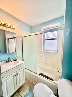 a bathroom with a granite countertop sink toilet a mirror and shower
