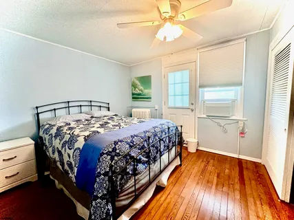 a bedroom with a bed and wooden floor