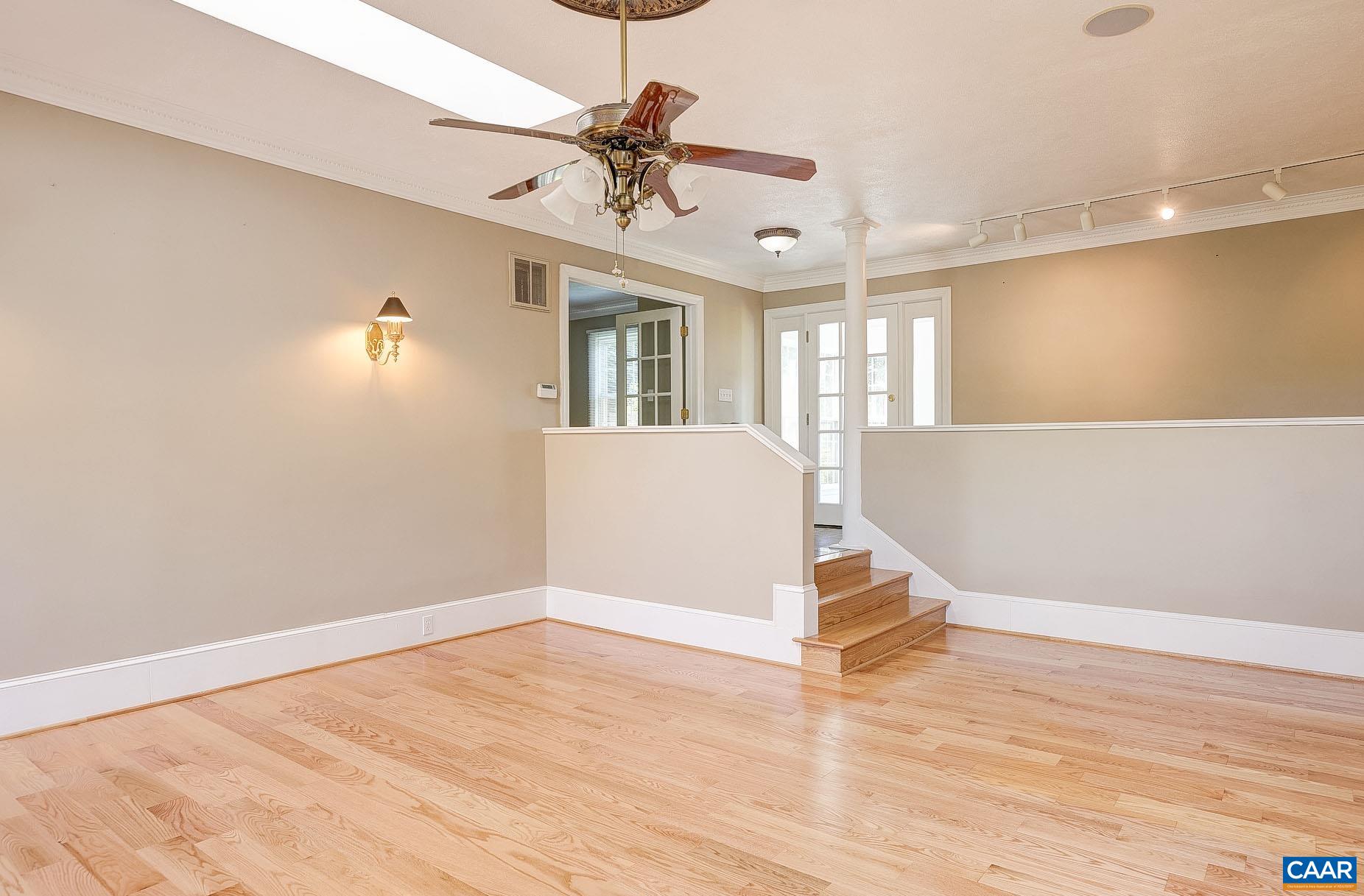 843 Campbell Road Keswick, VA 22947 - Photo 6 of 46 a view of an empty room with wooden floor and a ceiling fan