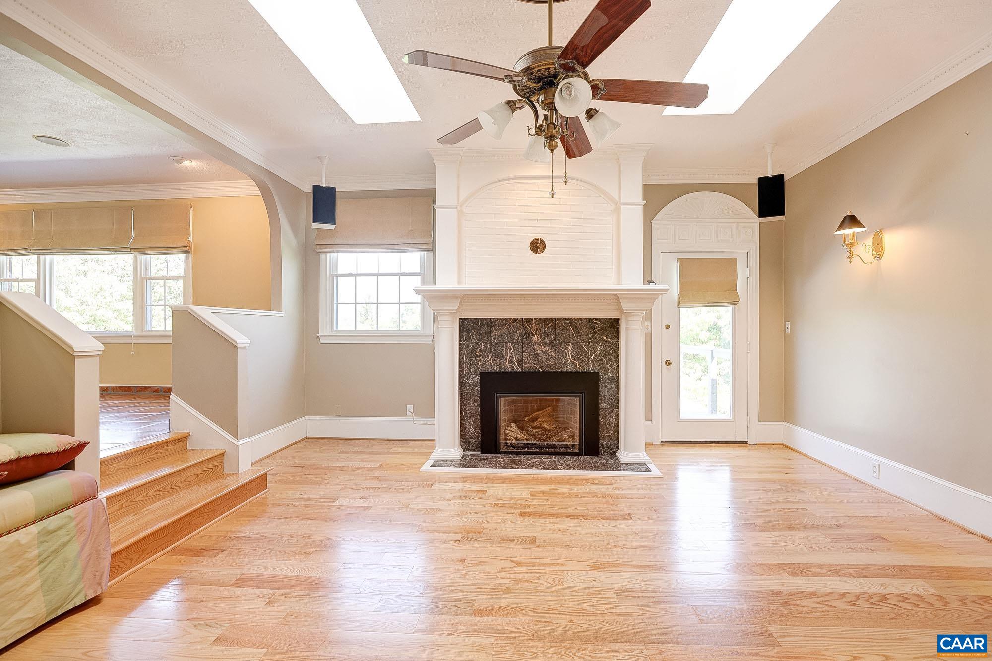 843 Campbell Road Keswick, VA 22947 - Photo 7 of 46 a view of a livingroom with a fireplace a ceiling fan and wooden floor