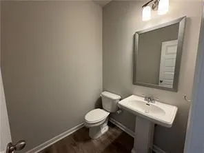 a bathroom with a sink toilet and mirror