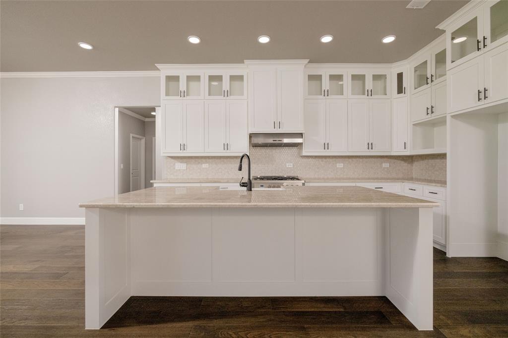 7196 Hawkeye Road Sanger, TX 76266 - Photo 20 of 26 Kitchen with under cabinet range hood, ornamental molding, decorative backsplash, and an island with sink
