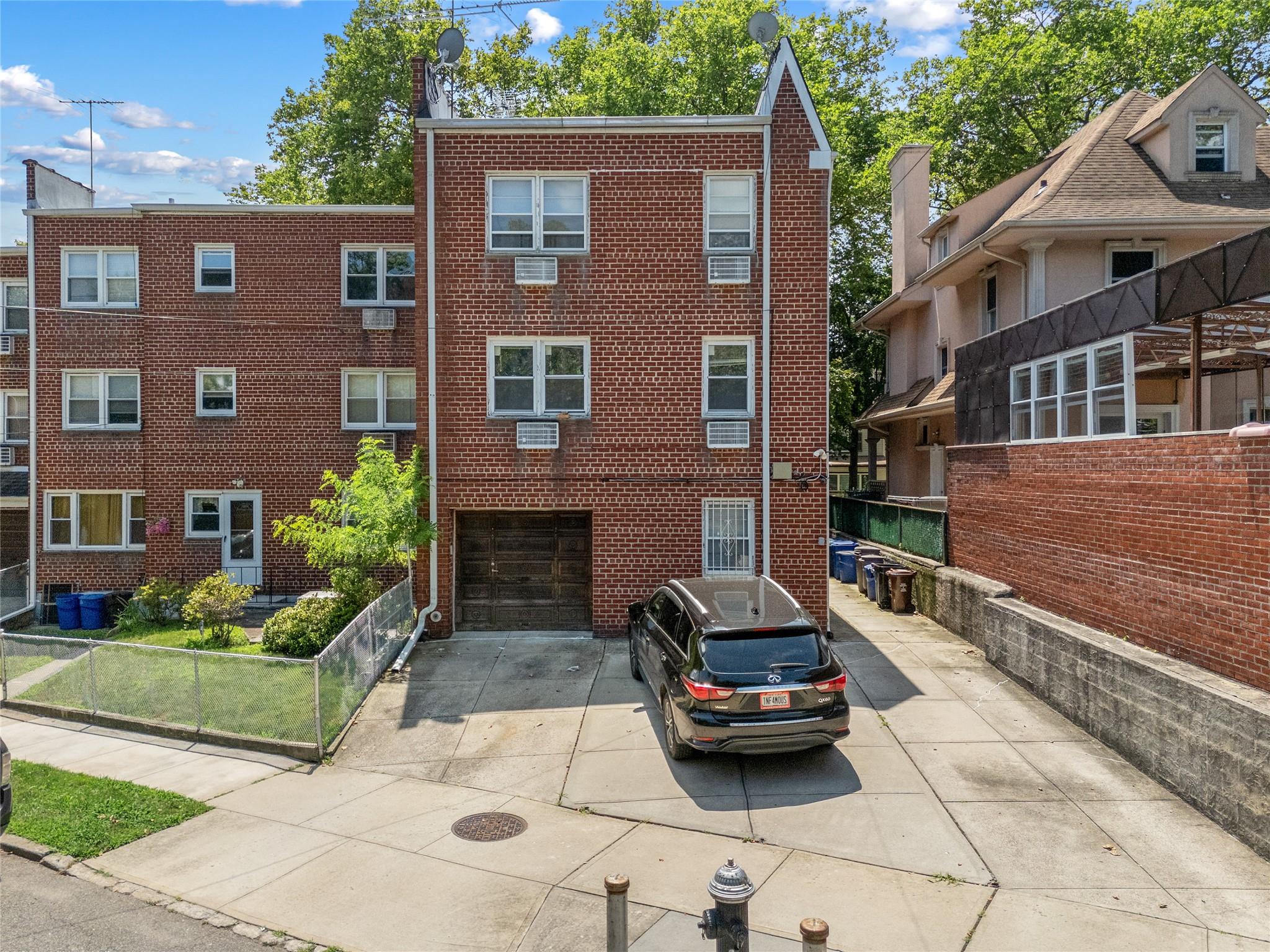 85-41 Abingdon Road Queens, NY 11415 - Photo 8 of 10 a car parked in front of a brick house