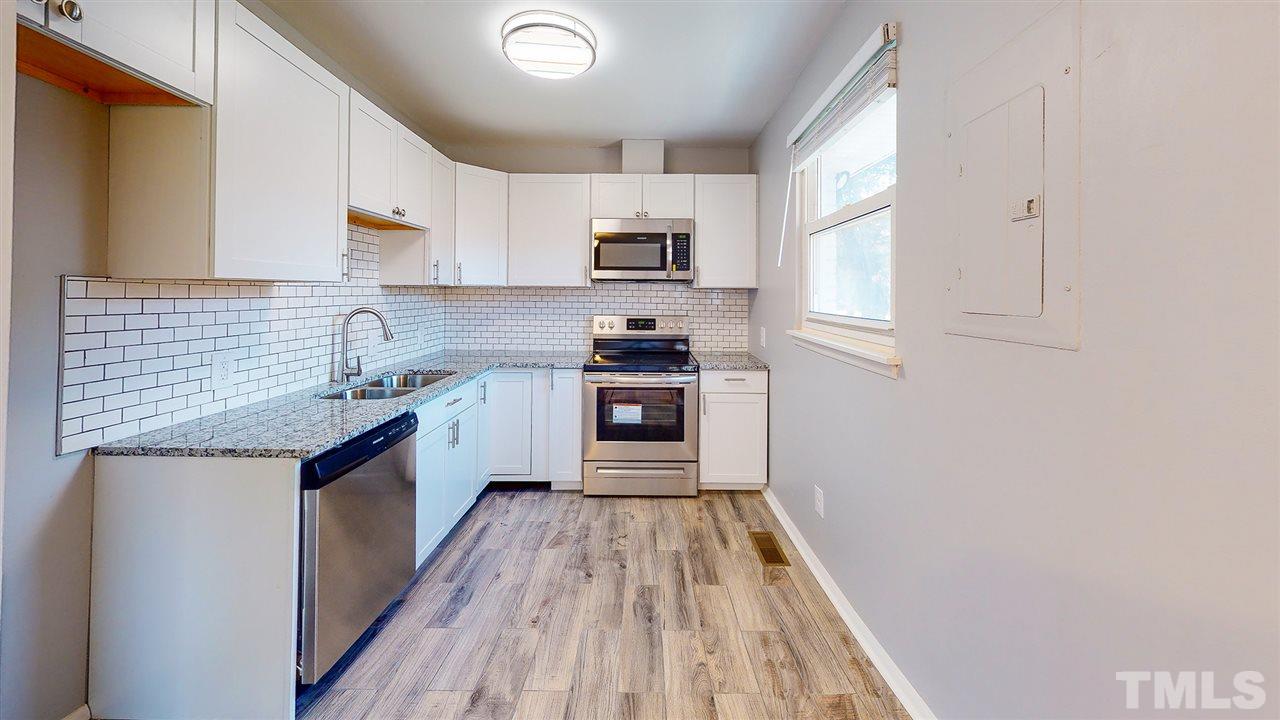 708 Hadley Road Raleigh, NC 27610 - Photo 7 of 20 a kitchen with granite countertop a sink wooden floor and stainless steel appliances