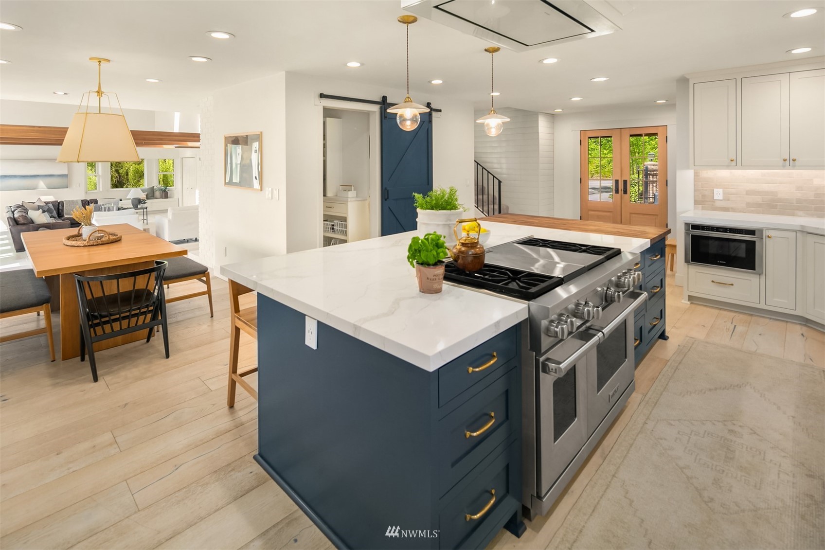 17227 Southeast May Valley Road Renton, WA 98059 - Photo 6 of 40 a kitchen with kitchen island a stove a sink a oven and a dining table with wooden floor
