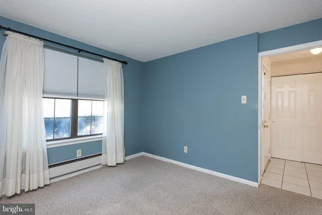 an empty room with cabinet and mirrors