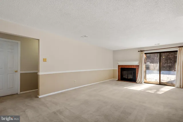 an empty room with fireplace and windows