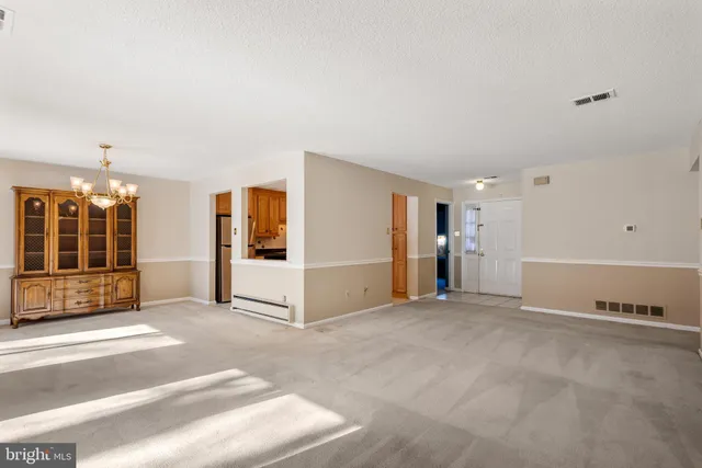 a view of an empty room with window and a living room