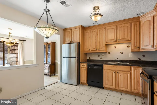 a kitchen with stainless steel appliances a stove a refrigerator and cabinets