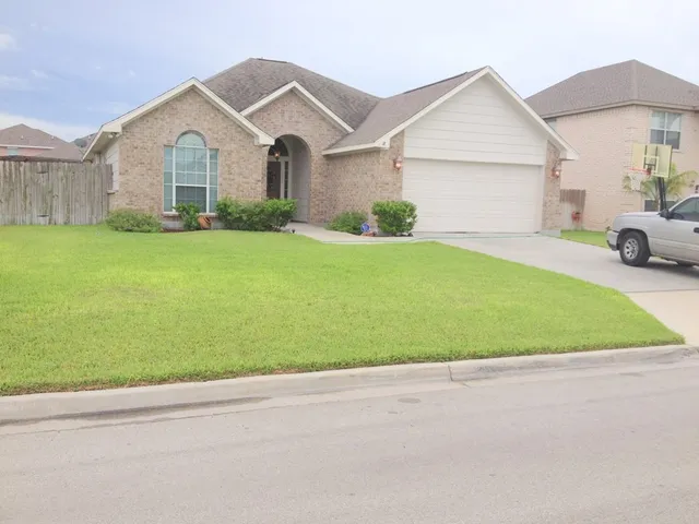 a front view of a house with a garden and yard