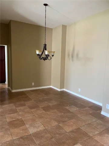 a view of a room with a chandelier fan