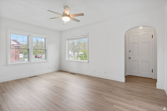 141 South 400 East Logan, UT 84321 - Photo 6 of 41 Unfurnished room with light wood-style flooring, arched walkways, and ceiling fan