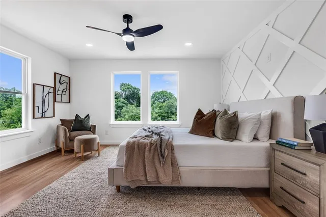 a bedroom with a bed couch and a large window