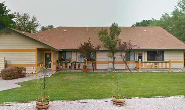 a front view of a house with a garden and plants