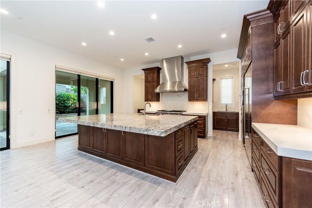 93 Spacial Irvine, CA 92618 - Photo 11 of 32 a kitchen with stainless steel appliances granite countertop a stove and a wooden floors