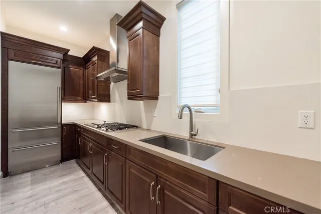 a kitchen with stainless steel appliances granite countertop a sink and a refrigerator