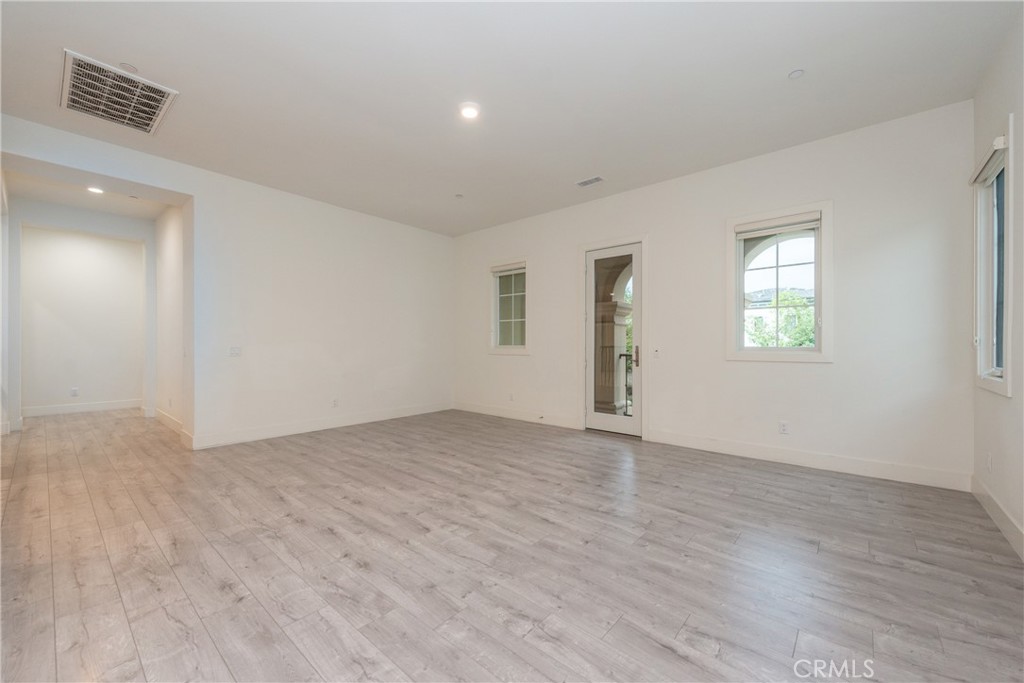 93 Spacial Irvine, CA 92618 - Photo 17 of 32 an empty room with wooden floor and windows