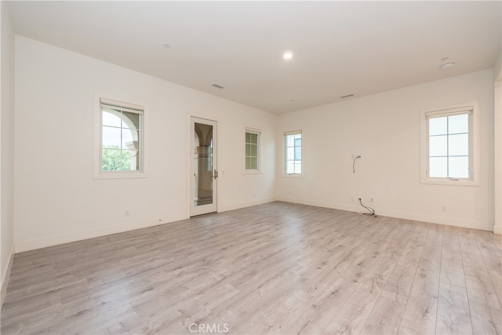 93 Spacial Irvine, CA 92618 - Photo 18 of 32 an empty room with wooden floor and windows