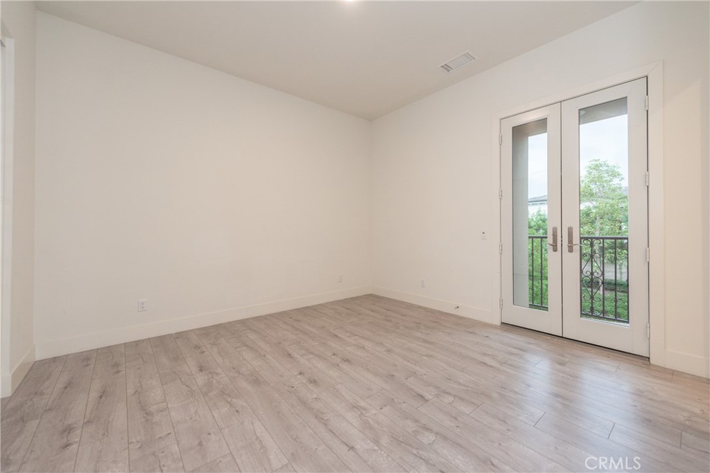 93 Spacial Irvine, CA 92618 - Photo 22 of 32 an empty room with wooden floor and windows
