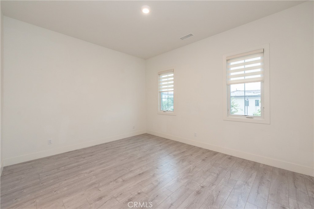 93 Spacial Irvine, CA 92618 - Photo 24 of 32 an empty room with wooden floor and windows
