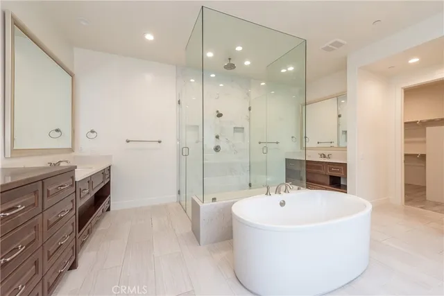 a bathroom with a tub sink shower and mirror