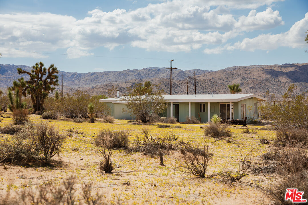 63670 Wagon Wheel Road Joshua Tree, CA 92252 - Photo 33 of 37 a view of a house with a yard covered with snow in the background