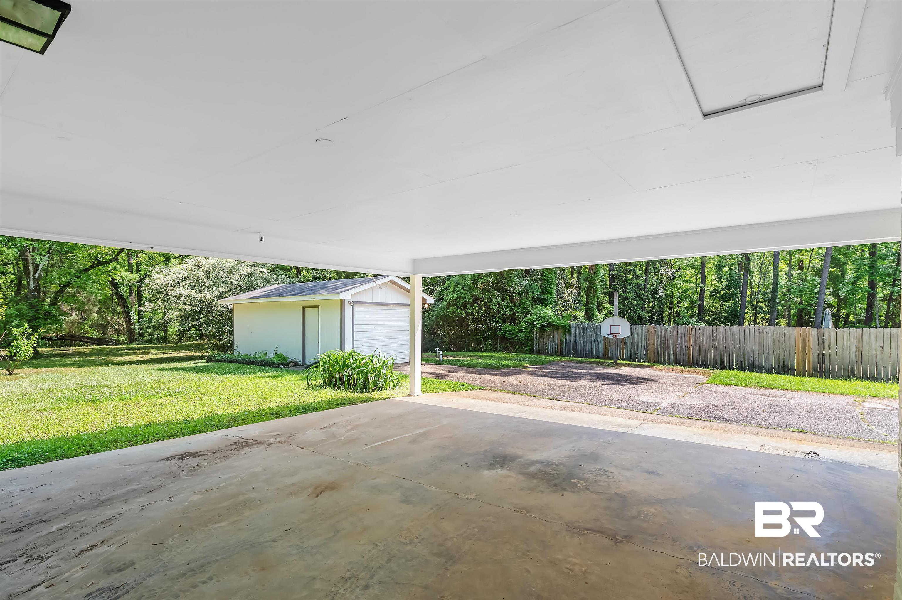 28 Caisson Trace Spanish Fort, AL 36527 - Photo 45 of 51 View of patio / terrace with an outdoor structure, a carport, and fence