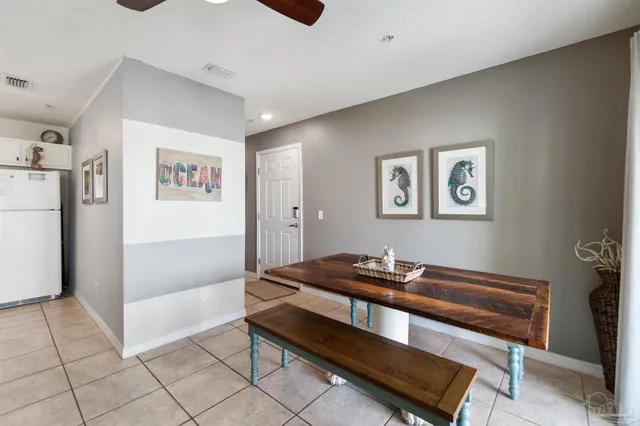 a hallway that has a couch and a refrigerator in it