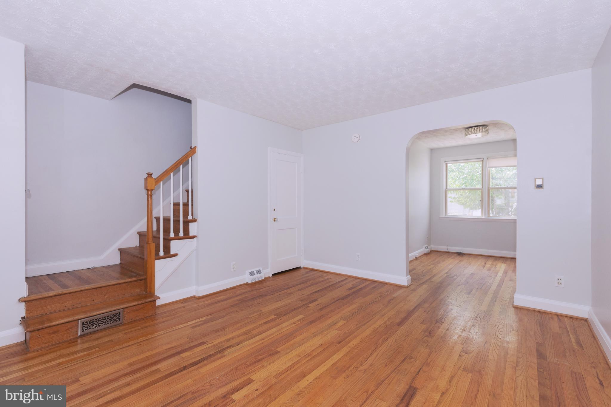 148 Wiltshire Road Baltimore, MD 21221 - Photo 7 of 28 a view of an empty room with wooden floor and a window