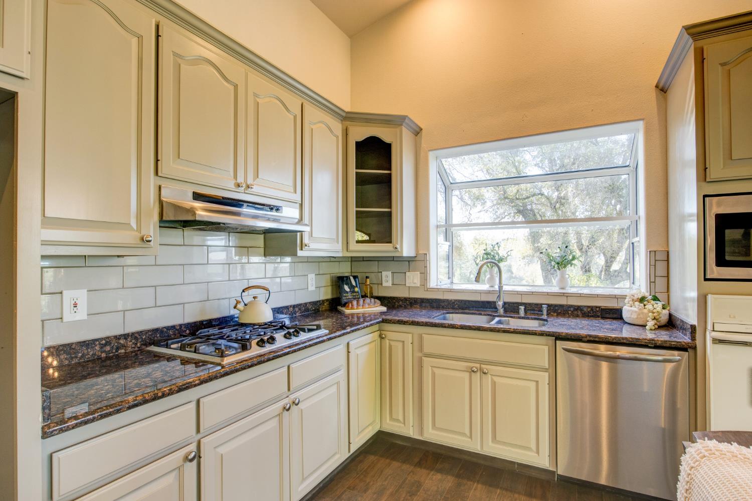3900 Tawanka Road Somerset, CA 95684 - Photo 13 of 84 a kitchen with stainless steel appliances granite countertop a sink a stove and white cabinets