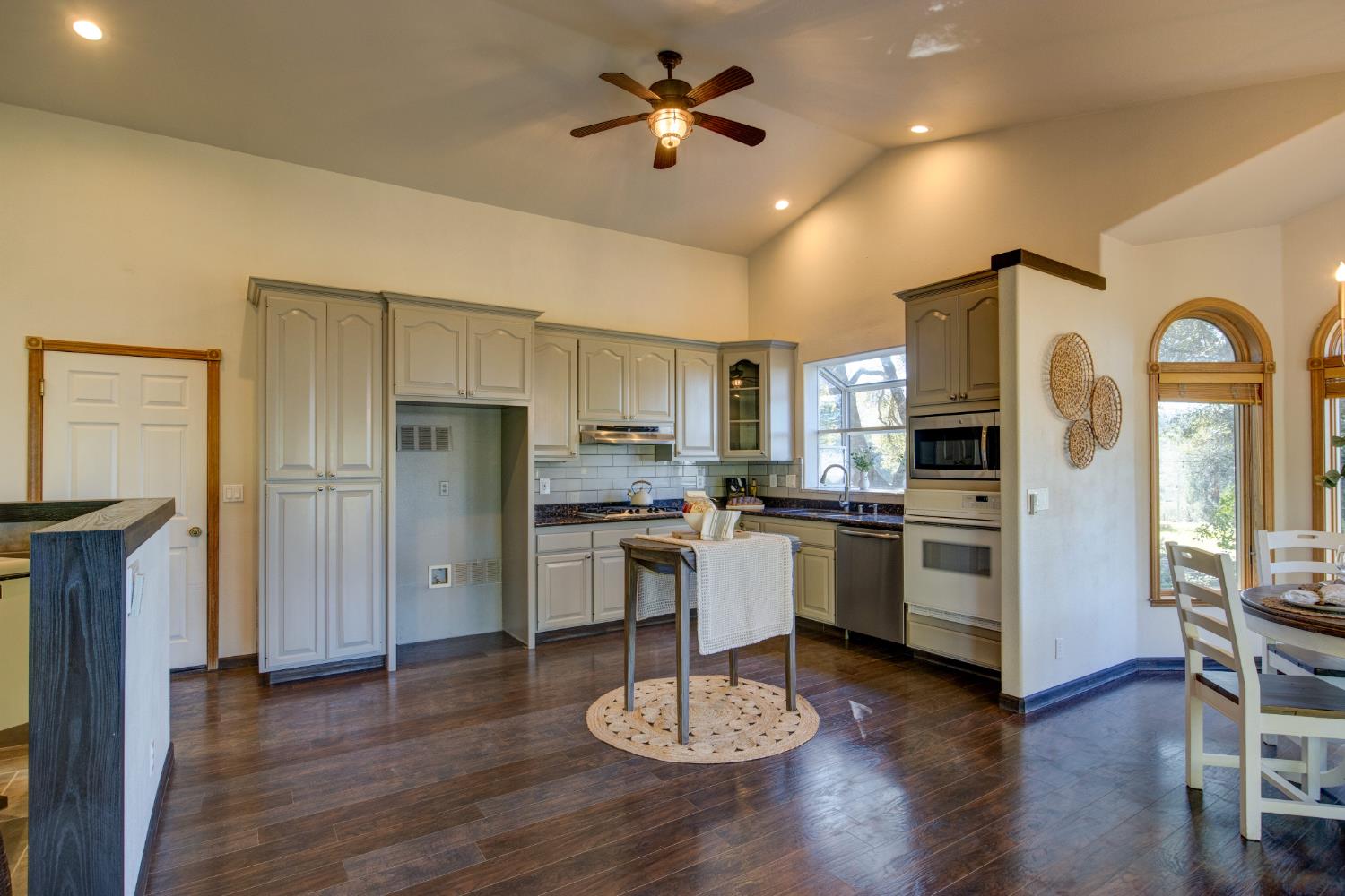 3900 Tawanka Road Somerset, CA 95684 - Photo 10 of 84 a kitchen with a refrigerator a stove a sink dishwasher a dining table and chairs with wooden floor