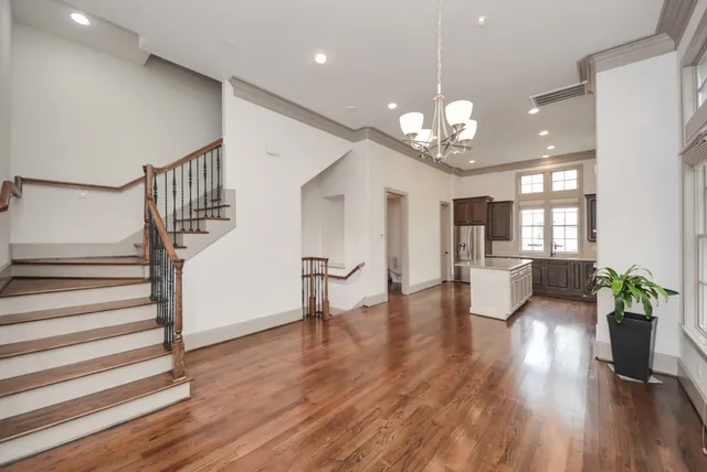 a view of a dining room with furniture a chandelier and wooden floor