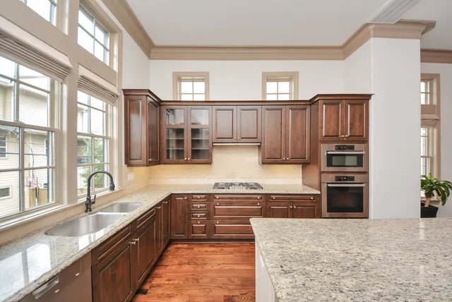 a kitchen with stainless steel appliances granite countertop a refrigerator and a stove top oven