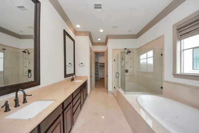 a spacious bathroom with a bathtub shower sink double and mirror