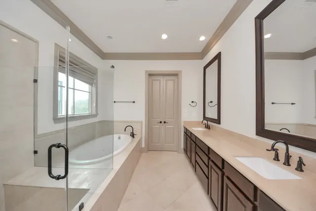 a spacious bathroom with a tub double sink and mirror