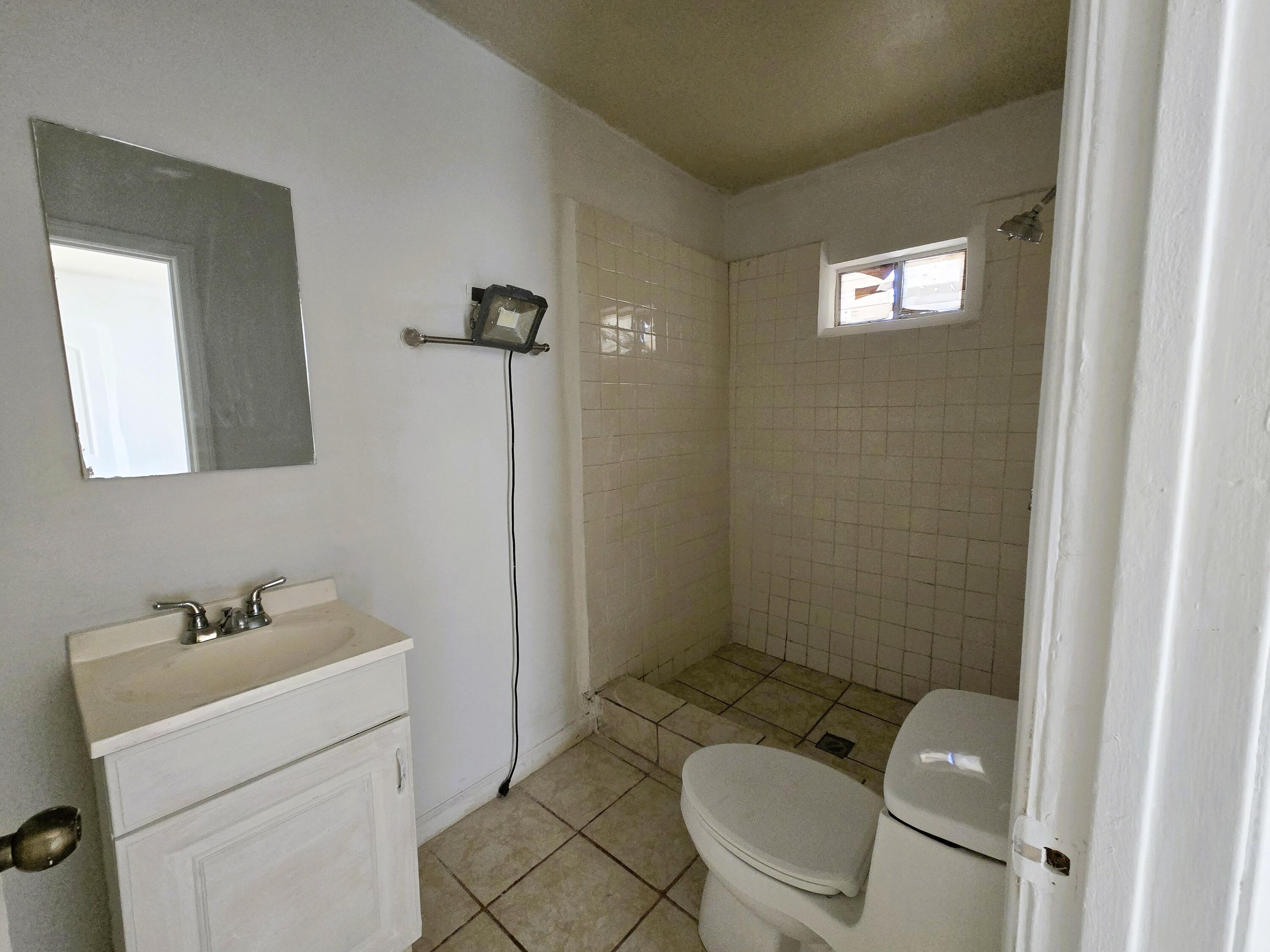 1423 2nd Street Coachella, CA 92236 - Photo 10 of 12 a white toilet sitting next to a bathroom sink