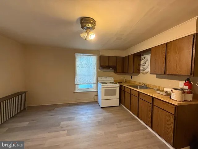 a kitchen with stainless steel appliances granite countertop a sink cabinets and wooden floor