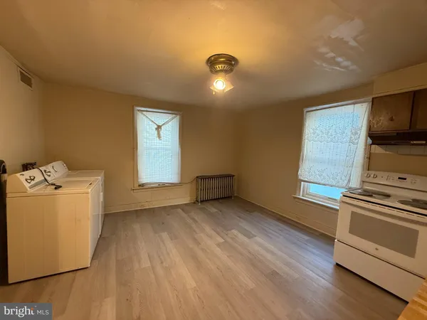 a view of a room with wooden floor and electronic appliances
