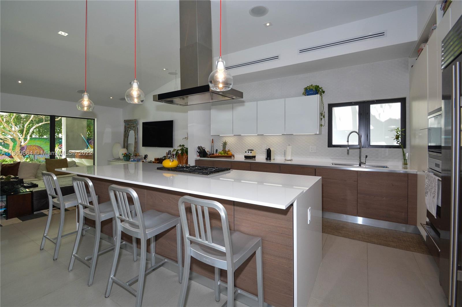 4560 Bay Point Road Miami, FL 33137 - Photo 10 of 40 a kitchen with stainless steel appliances granite countertop a sink a stove a refrigerator cabinets and chairs