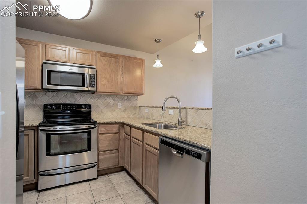 605 Cougar Bluff Point, Unit 210 Colorado Springs, CO 80906 - Photo 16 of 33 a kitchen with a sink and stainless steel appliances